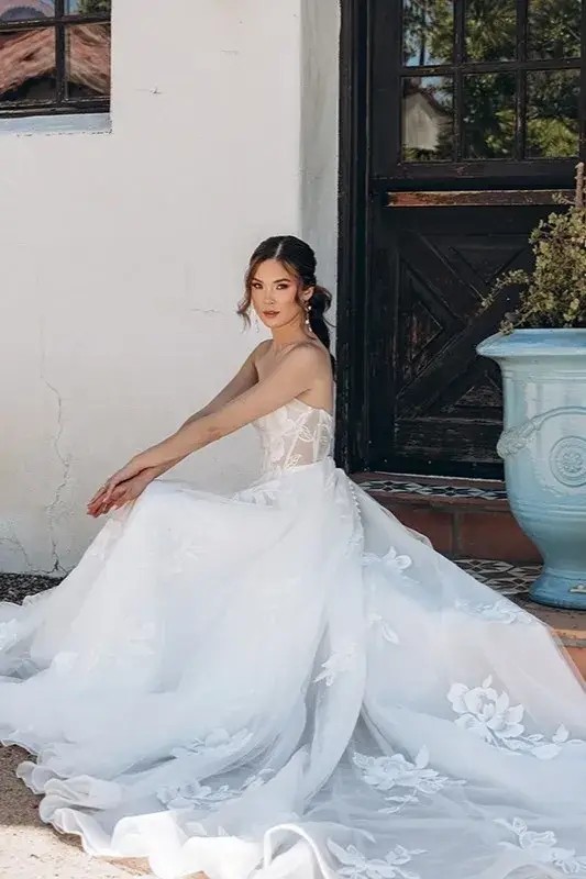model is wearing a strapless a-line wedding dress with floral embroidery