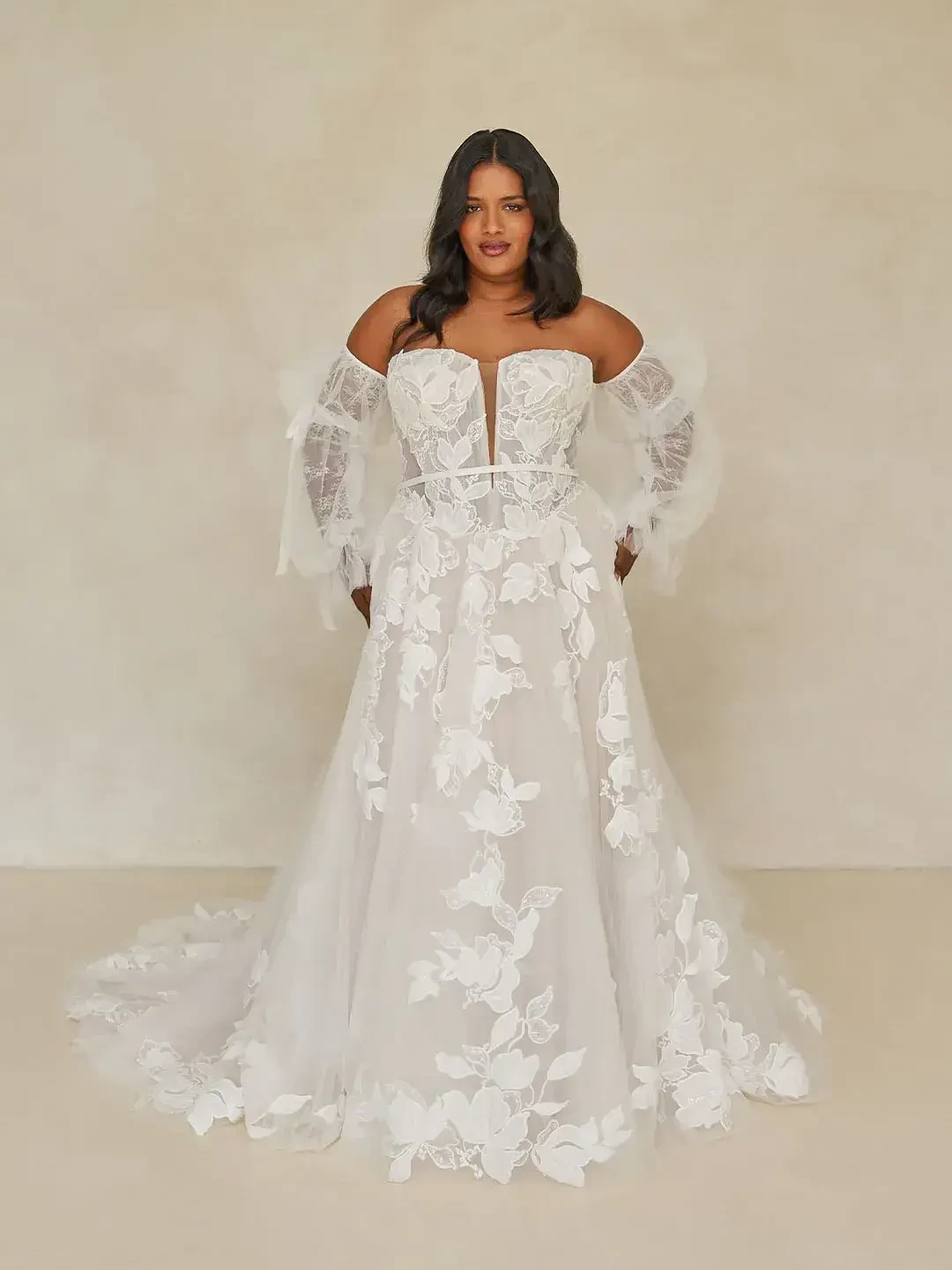 model is wearing an off the shoulder a-line bridal gown