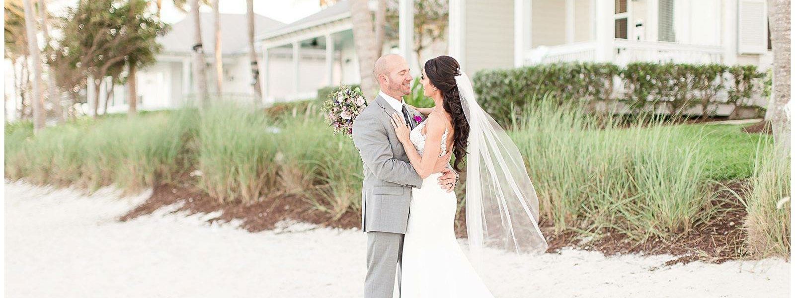 Сouple wearing a white gown and a gray suit. Mobile image